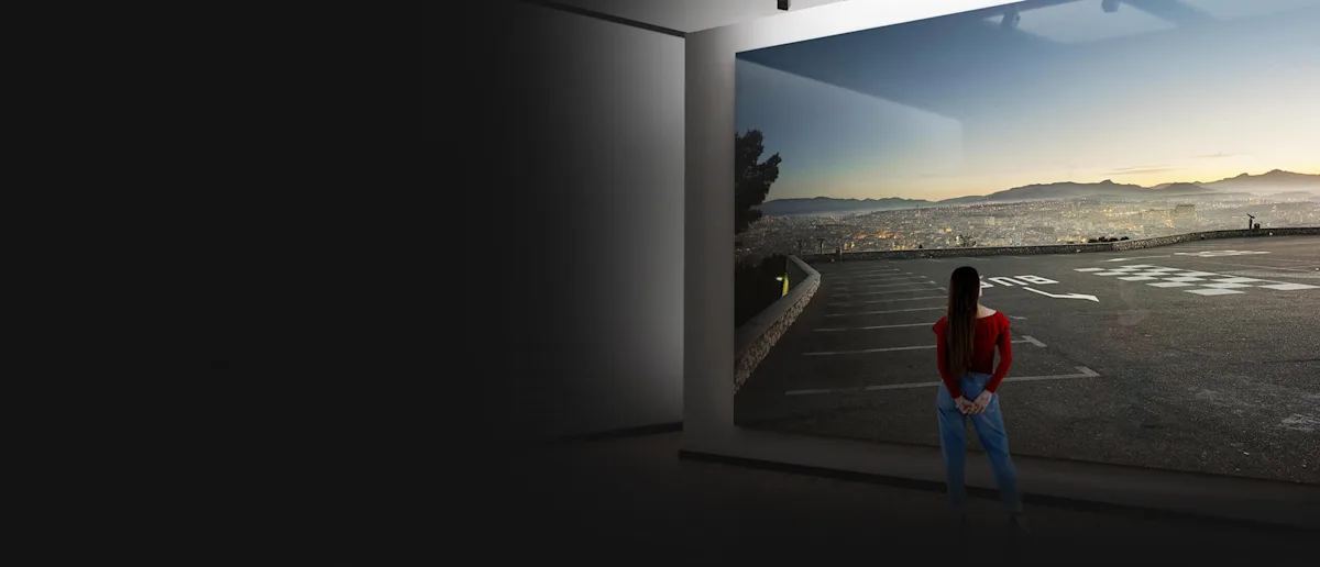 WhiteWall Masterprint Woman in a red sweater looks at a WhiteWall master print depicting a city in the distance.