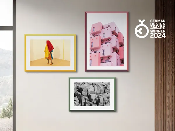WhiteWall Design Edition Gallery wall displaying four framed artworks: colorful figure, pink building, black and white rocks, and German Design Award 2024 logo
