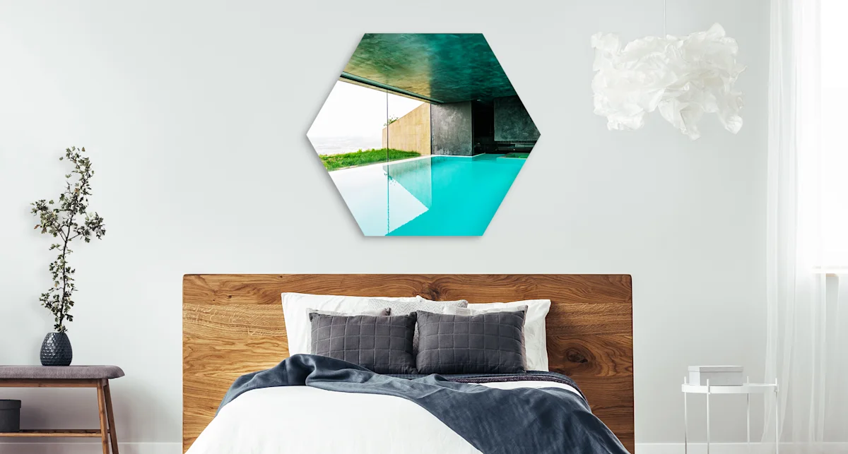 PDP | Round Format & Shapes | Big Picture Slider Section > Hexagon | Slide #2 | Media #1 The overview of a pool with a view of the sea hangs in a hexagon format above a bed.