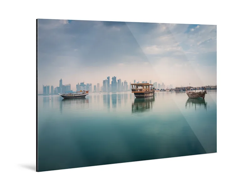 Photo Print On Aluminum Backing Three boats are reflected on the calm surface of the sea, visible on a photo print on an aluminum base.