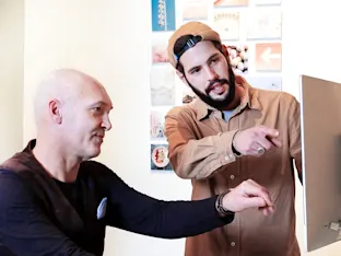 GLOBAL | Product Tiles Section > Support | Media #1 a customer pointing at a computer screen with whitewall expert sitting in front of it.