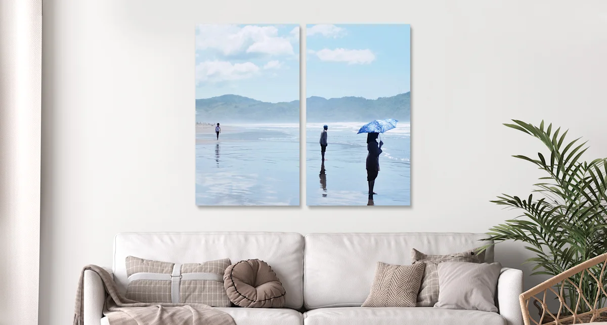 PDP | Multi Panel Wall Art | Big Picture Slider Section > Eye catcher | Slide #1 | Media #1 People standing on a beach in the sea. The whole picture is divided into two parts hanging horizontally on the wall.