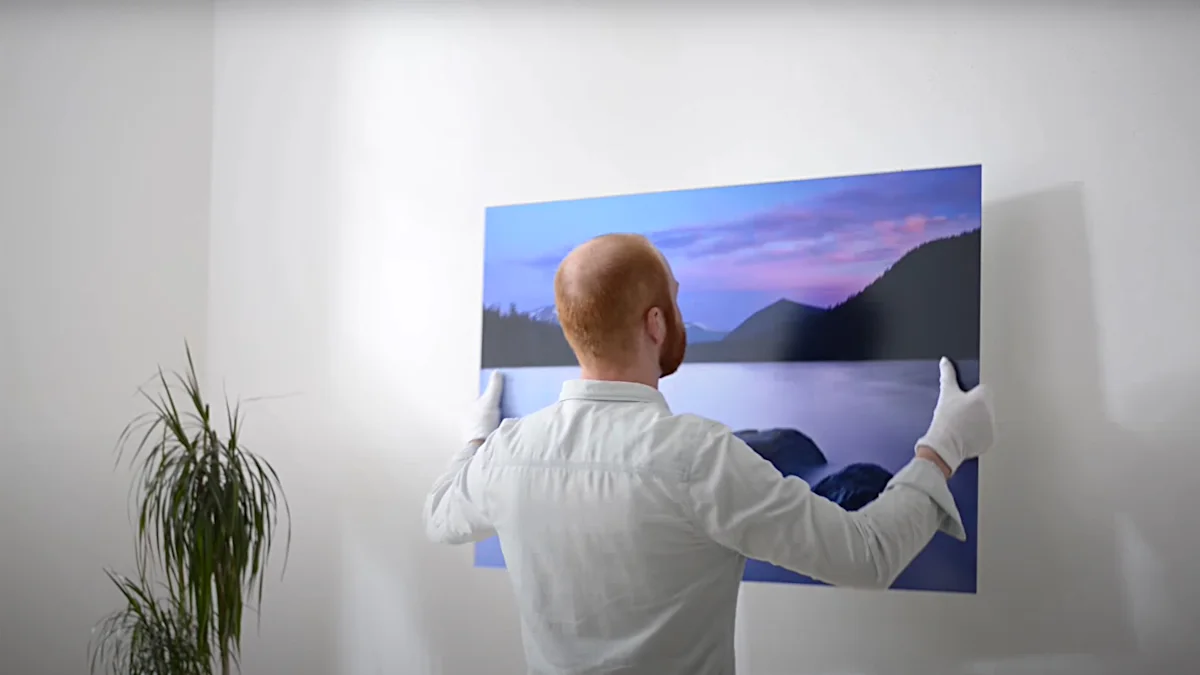 Global | PDP | Video Section > Bilder richtig aufhängen | Media #1 A man hangs a picture on the wall.